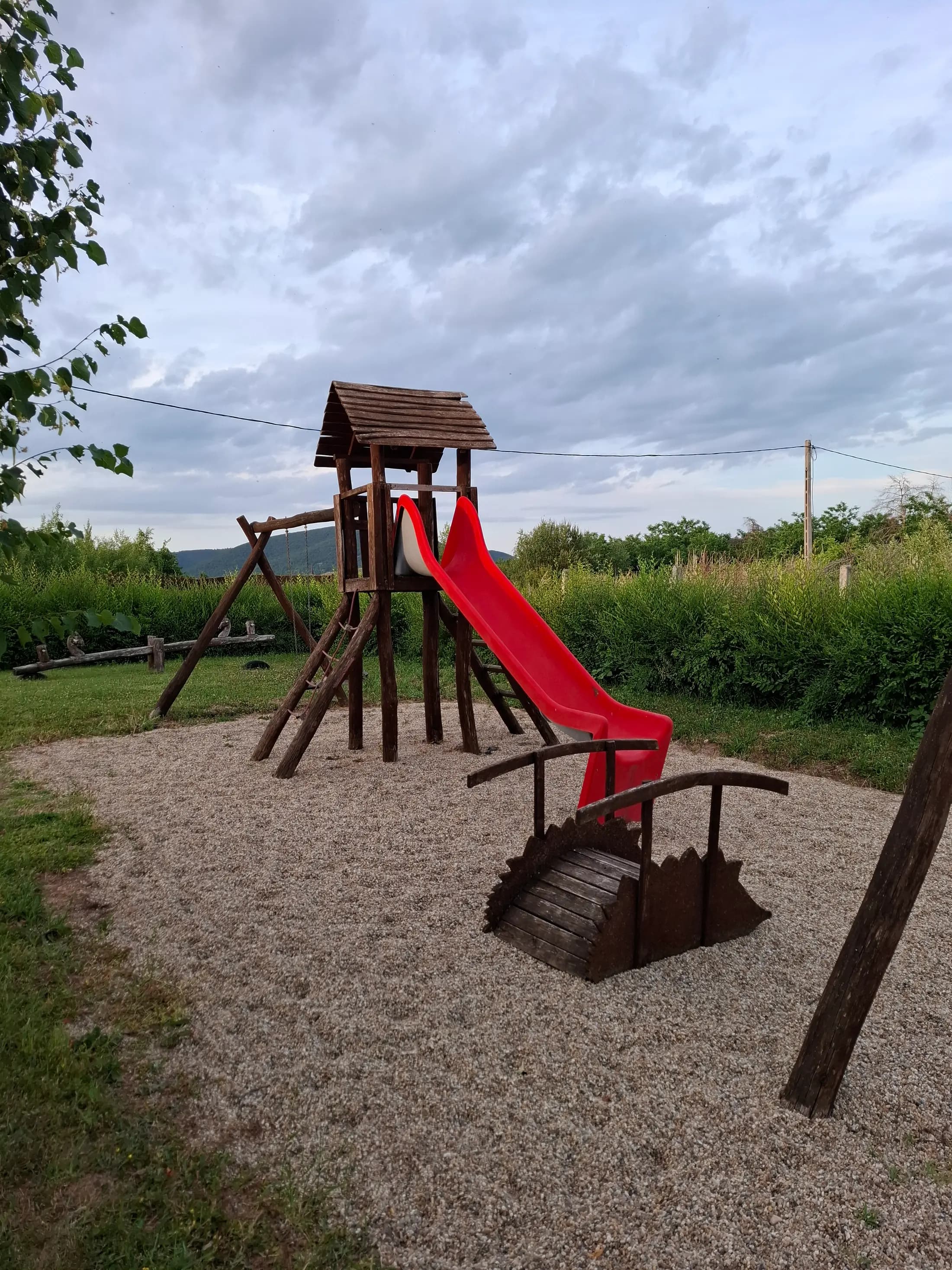 Az előkertben játszótér homokozóval, mászókával, csúszdákkal és hintákkal